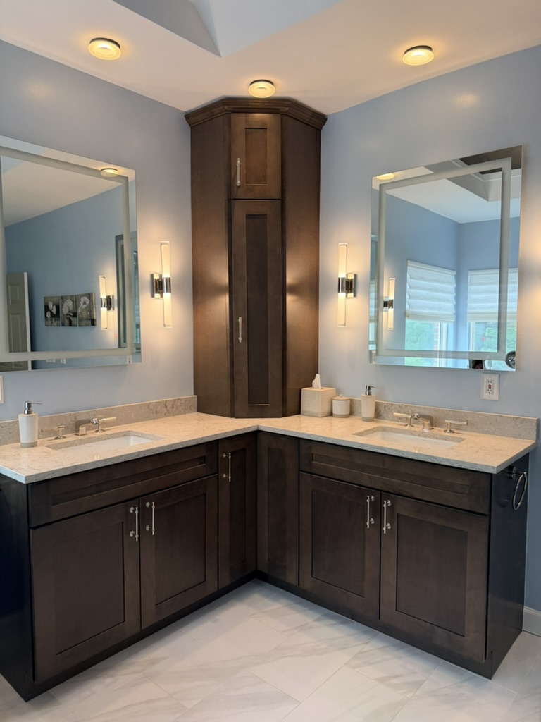Primary bathroom with dark wood dual vanity and framed mirrors